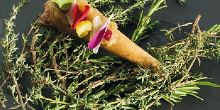 Se trata de un atuténtico festín visual y culinario. Un singular bocado, explosión de sabores y colores cuidadosamente combinados. Un canutillo relleno de tierna carne de vaca combinado con un praliné de cebolla y remolacha picante, coronado con encurtidos y pétalos de flor comestibles.